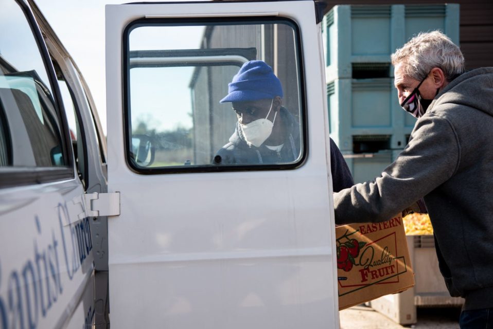 Volunteer loading van with produce