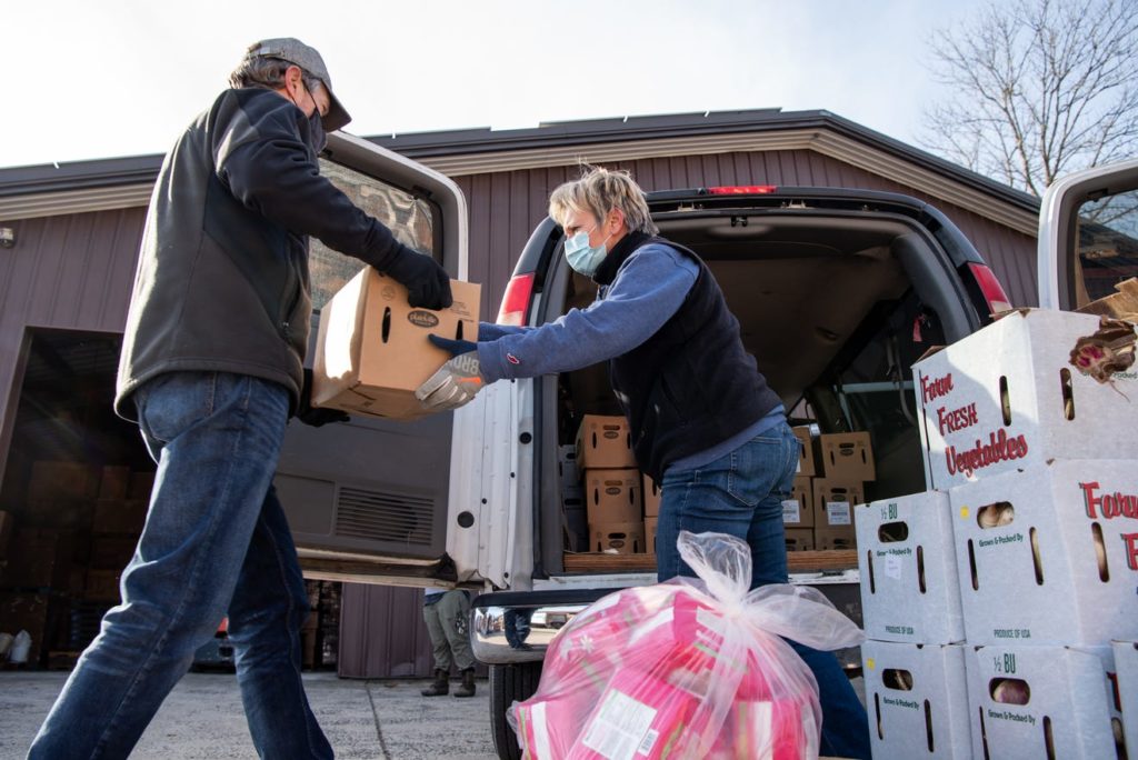 Volunteers loading van with produce